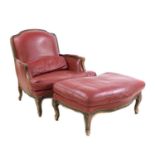 A large French beech and red leather upholstered armchair and 'run up' stool