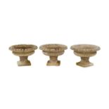 A series of three composite stone garden urns,