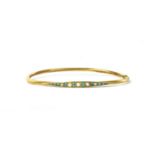 An Edwardian gold split pearl and turquoise oval bangle,