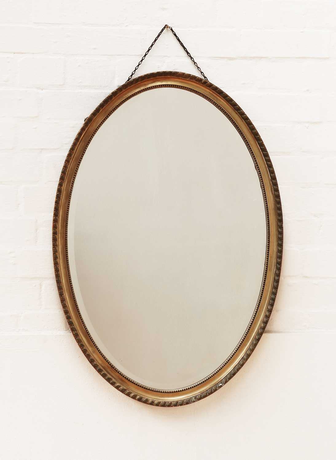 A George III-style oval wall mirror,