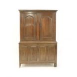 An early 18th century provincial oak press cupboard with a simple moulded cornice,