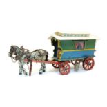 A painted wooden model of a gypsy caravan and horse