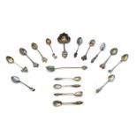 A collection of seventeen silver, silver plated and enamelled souvenir spoons,