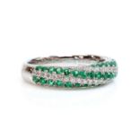 An 18ct white gold emerald and diamond half hoop ring,