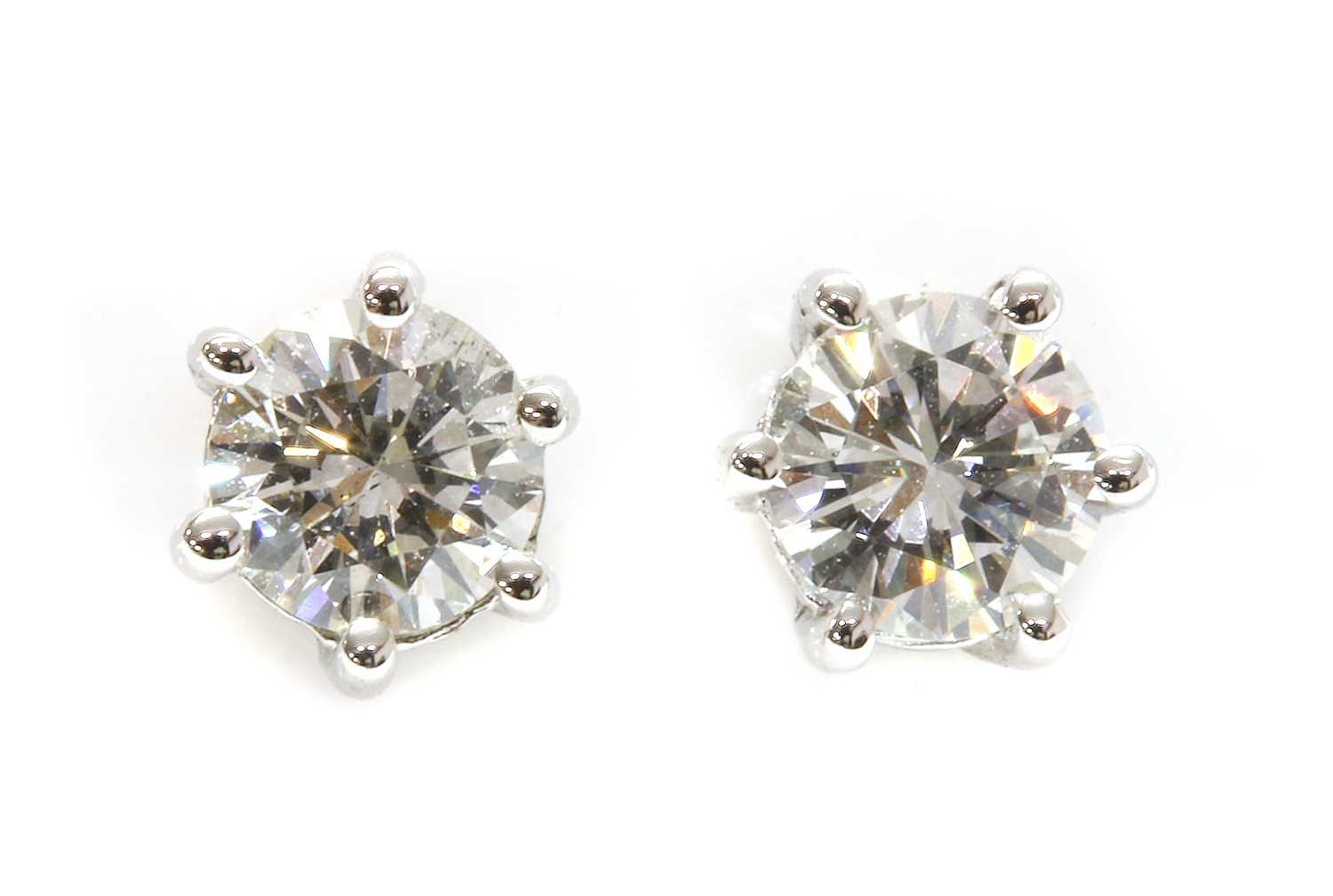 A pair of single stone diamond stud earrings,