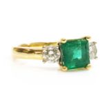 An 18ct two colour gold three stone emerald and diamond ring,