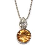 An 18ct white gold topaz and diamond pendant,