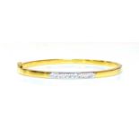 An 18ct two colour gold diamond set hinged bangle,