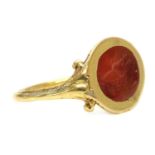 A gold cornelian intaglio ouroboros ring,