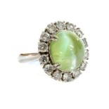 A platinum, chrysoberyl cat's eye and diamond oval cluster ring,