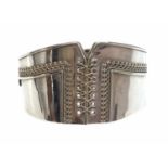 A Victorian sterling silver hinged bangle of corset form,