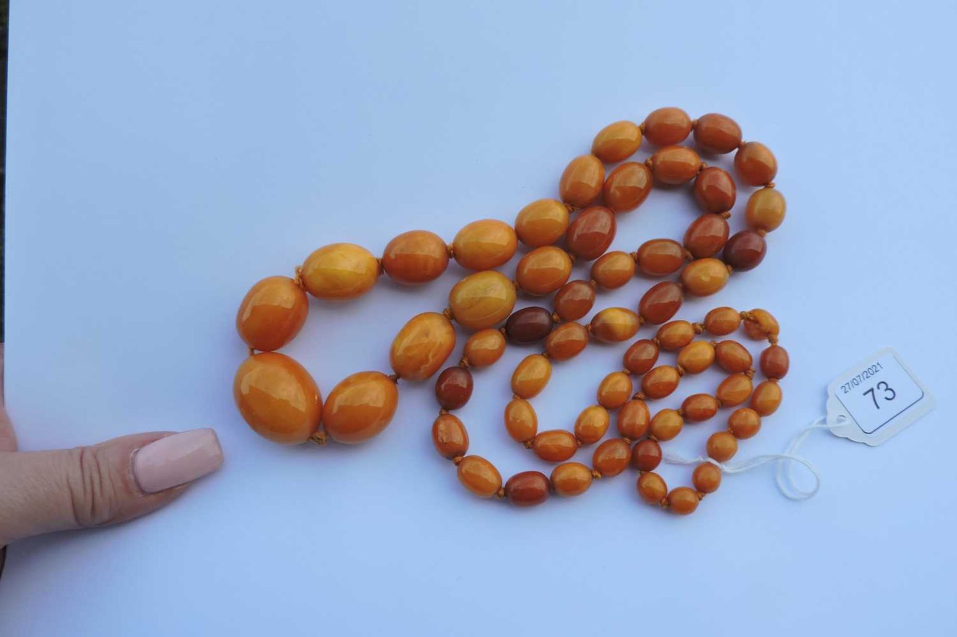 A single row graduated olive shaped amber bead necklace, - Image 3 of 4