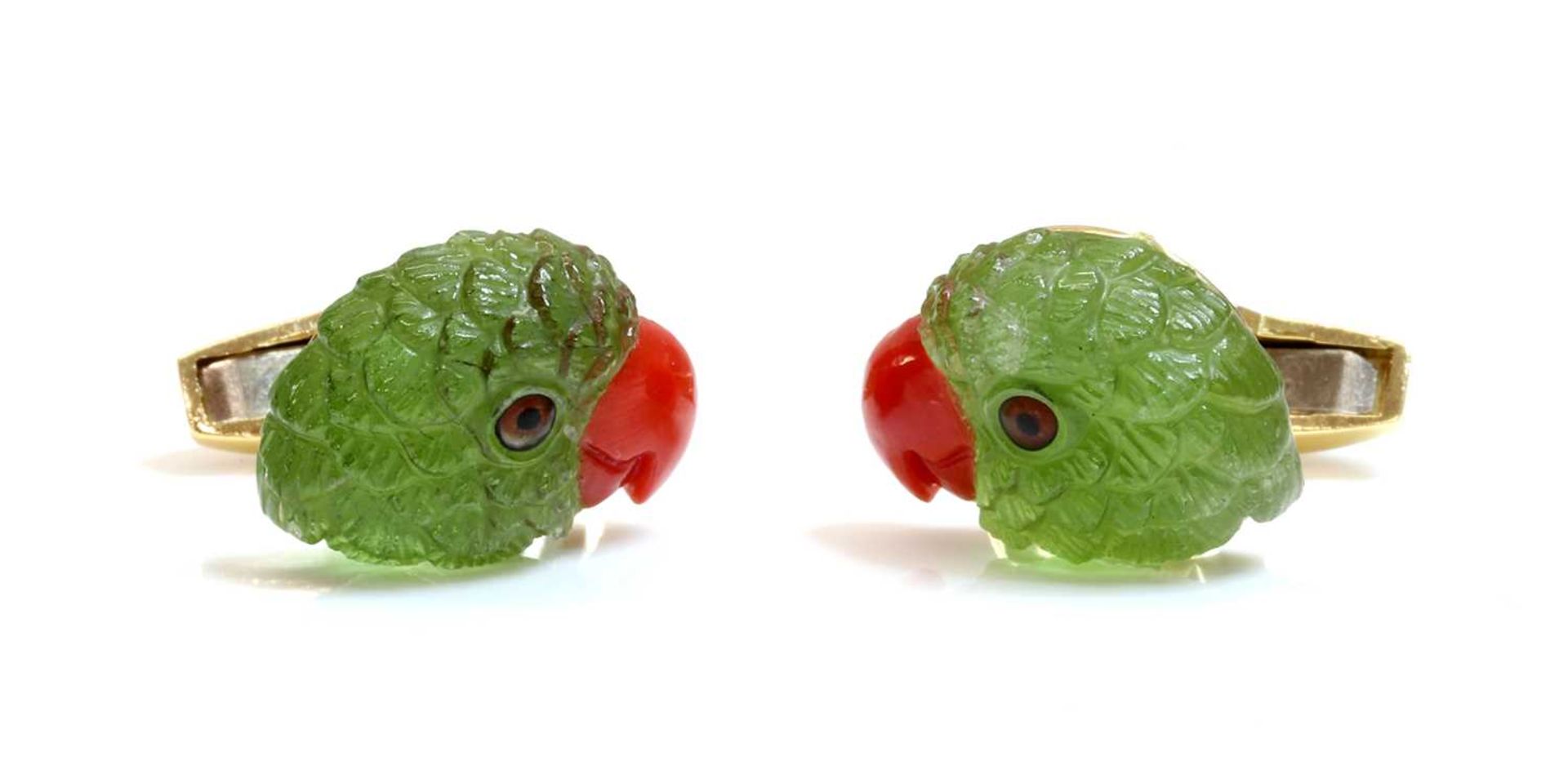 A pair of 18ct gold carved peridot and coral parrot head cufflinks, by Deakin & Francis, retailed by