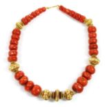 A single row graduated coral and high carat gold bead necklace,