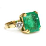 An emerald and diamond three stone ring,