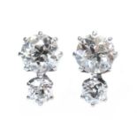 A pair of two stone diamond stud earrings,