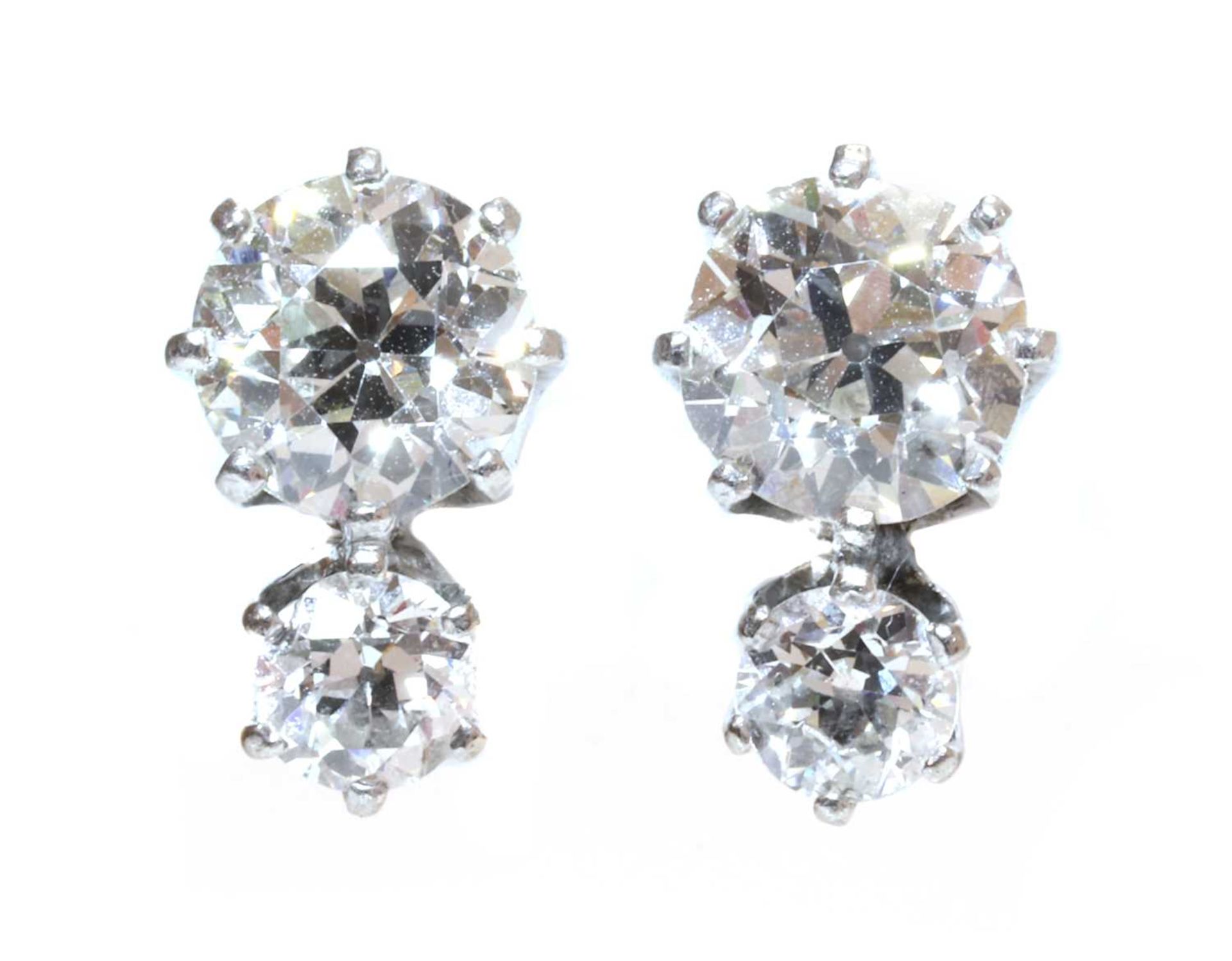 A pair of two stone diamond stud earrings,