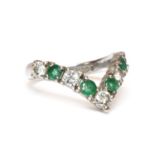 An 18ct white gold diamond and emerald half wishbone ring,