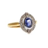 An 18ct yellow and white gold sapphire and diamond oval cluster ring,