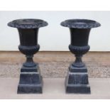 A pair of cast iron black painted campana form garden urns,