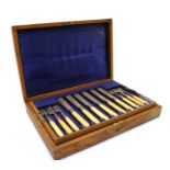 An oak cased set of eight fish knives and forks,