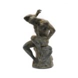 A Grand Tour type bronze statue of a nude male seated on a tree stump,