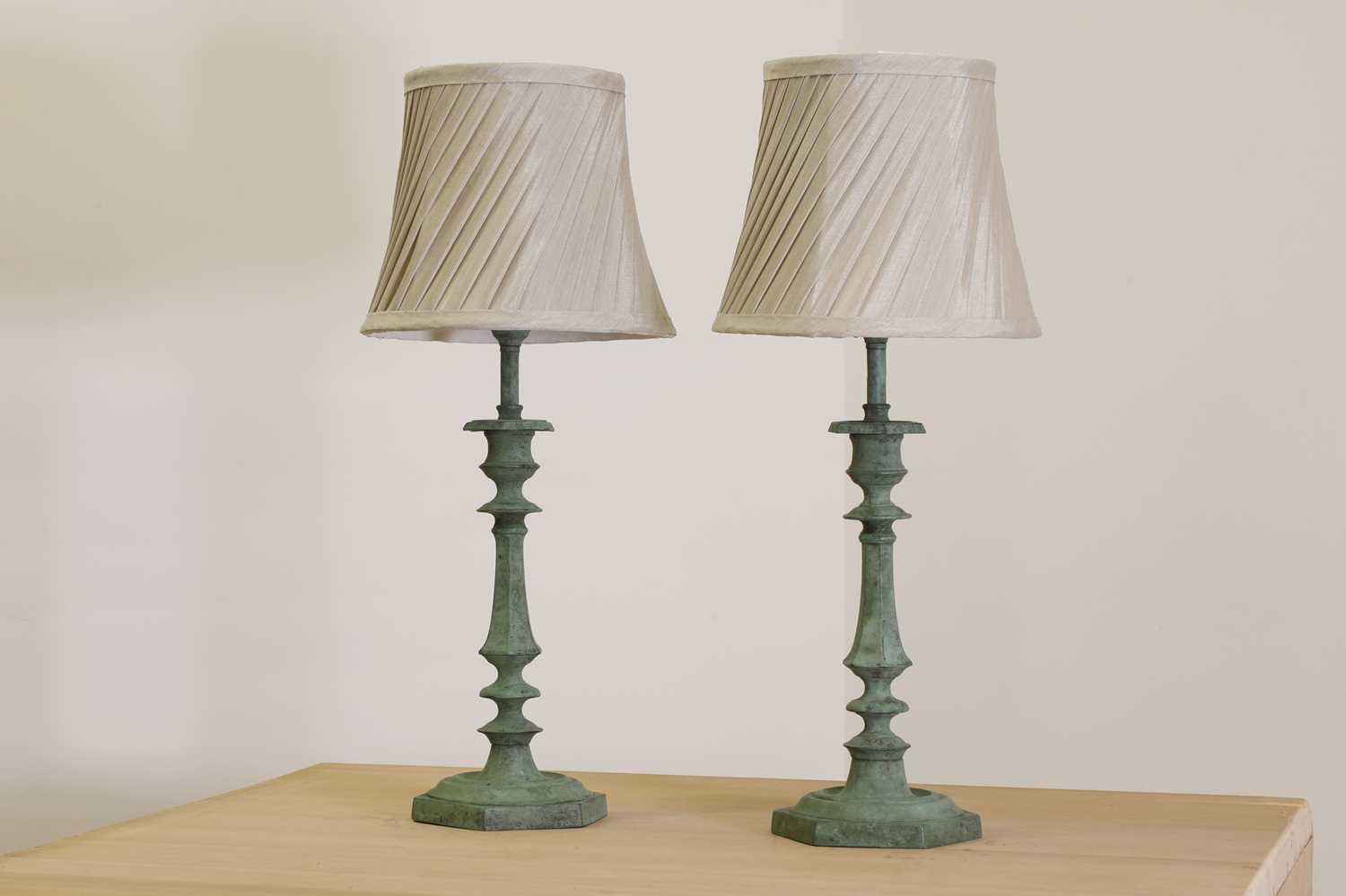 A pair of verdigris candlestick lamps,