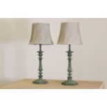 A pair of verdigris candlestick lamps,