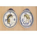 A pair of oval moulded pottery plaques,