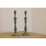 A pair of verdigris candlestick lamps,