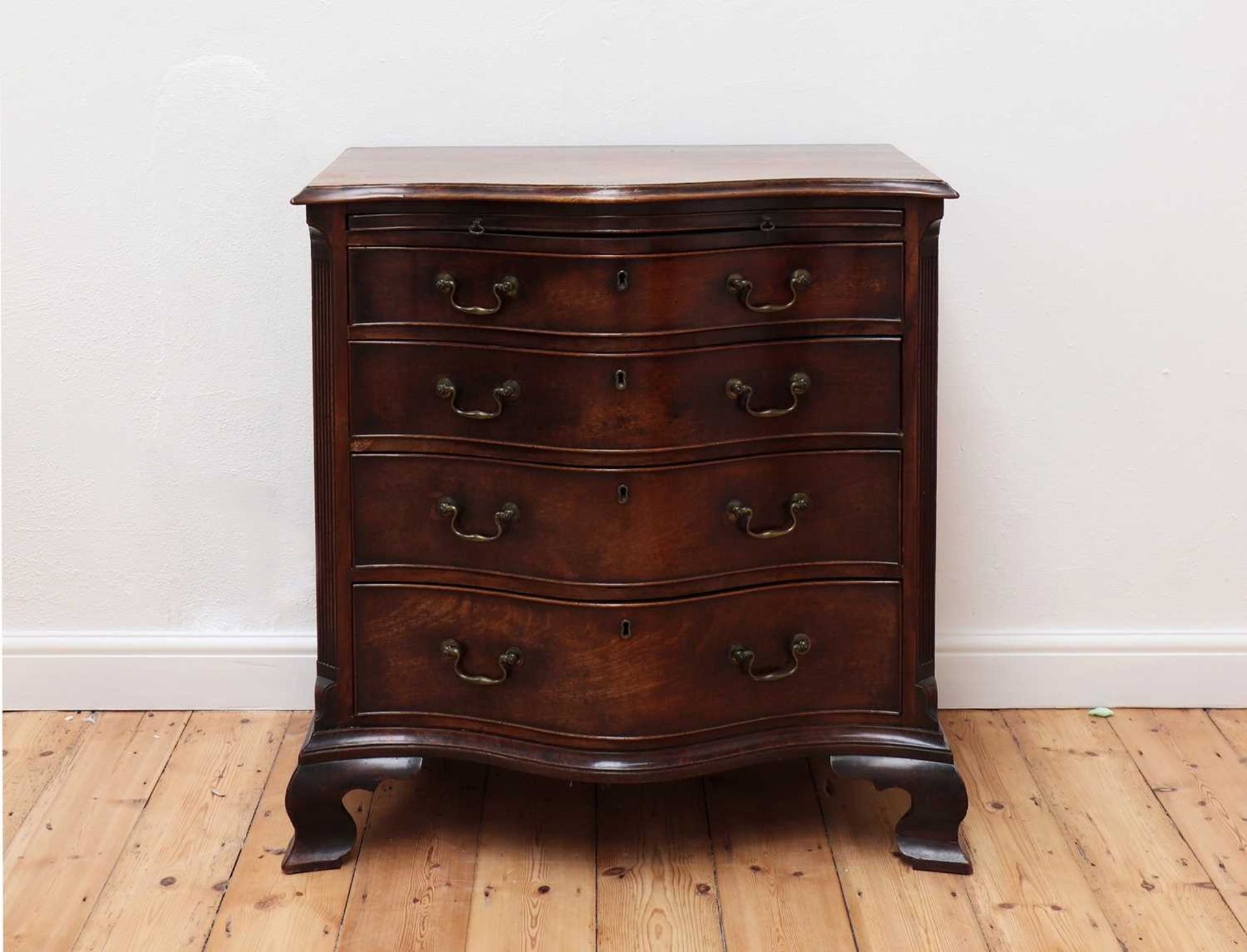 A George III serpentine mahogany chest of drawers,