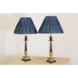 A pair of French Empire-style patinated and gilt-bronze candlestick lamps