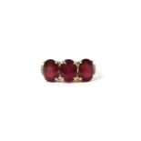 A gold three stone fracture filled ruby ring,