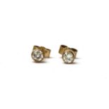 A pair of gold single stone diamond earrings,