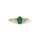 A gold emerald and diamond ring,