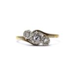 A gold three stone diamond crossover ring,