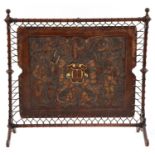 An embossed leather and walnut fire screen,