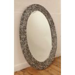 A contemporary oval aluminium mirror,