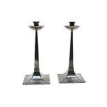 A pair of Arts and Crafts-style silver candlesticks,