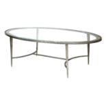 An oval glass-topped aluminium coffee table,