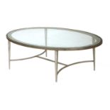An oval glass-topped aluminium coffee table,