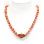 A single row uniform coral bead necklace,