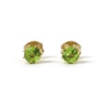 A pair of gold single stone peridot stud earrings,