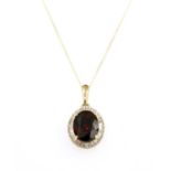 A gold garnet and diamond cluster pendant,