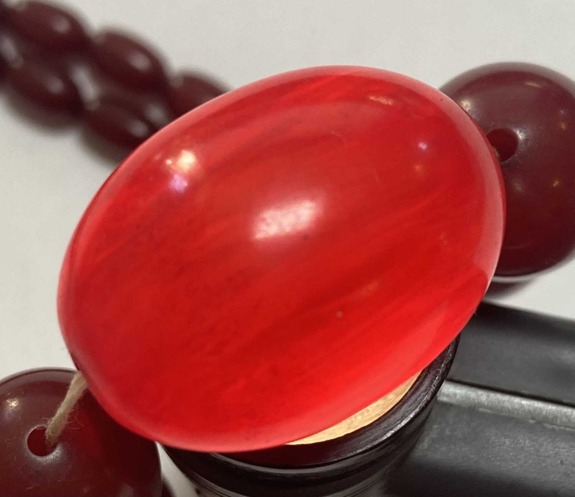 A single row graduated cherry coloured Bakelite bead necklace, - Image 4 of 4