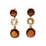 A pair of gold three stone garnet drop earrings,