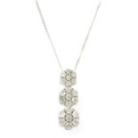 A white gold diamond cluster pendant,