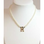 A single row pearl and diamond initial necklace,