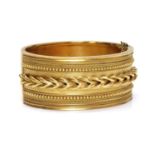 A cased Victorian gold archaeological revival, Etruscan style hinged bangle, c.1860,