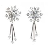 A pair of 18ct white gold diamond set star burst drop earrings,